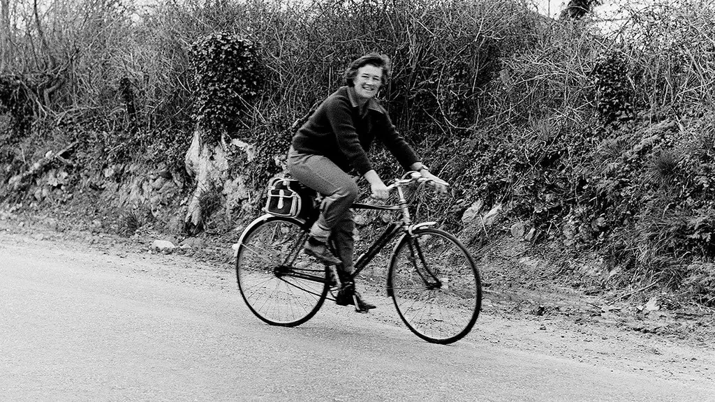 Dervla Murphy à vélo dans une vallée de montagne en Afghanistan