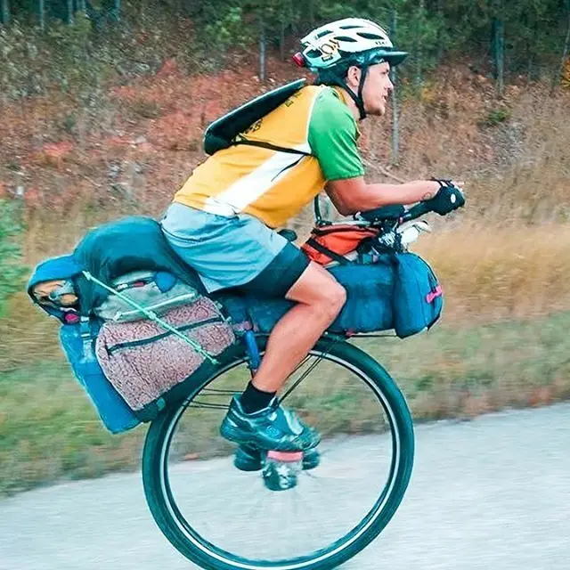 Ed Pratt sur son monocycle traversant une route de campagne